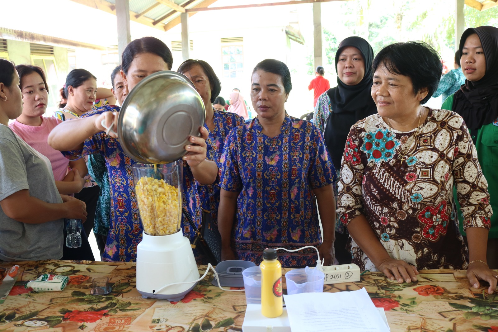 Foto: Ibu-ibu peserta kegiatan PPM melakukan praktik mengolah Susu Jagung Manis.