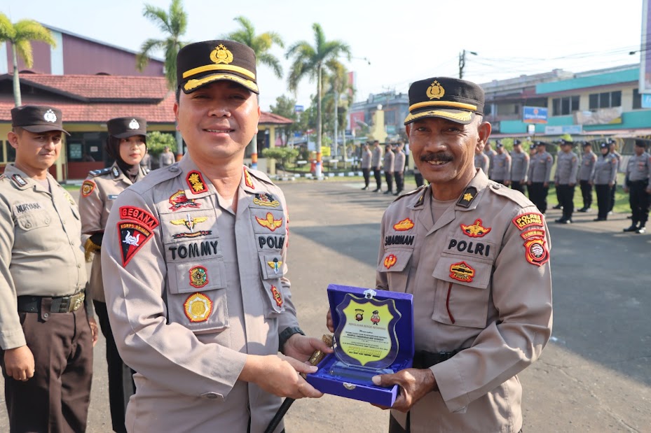 CENDERAMATA: Kapolres AKBP Tommy Ferdian, menyerahkan piagam penghargaan serta cenderamata kepada Kompol Sabariman yang memasuki masa pensiun. ISTIMEWA