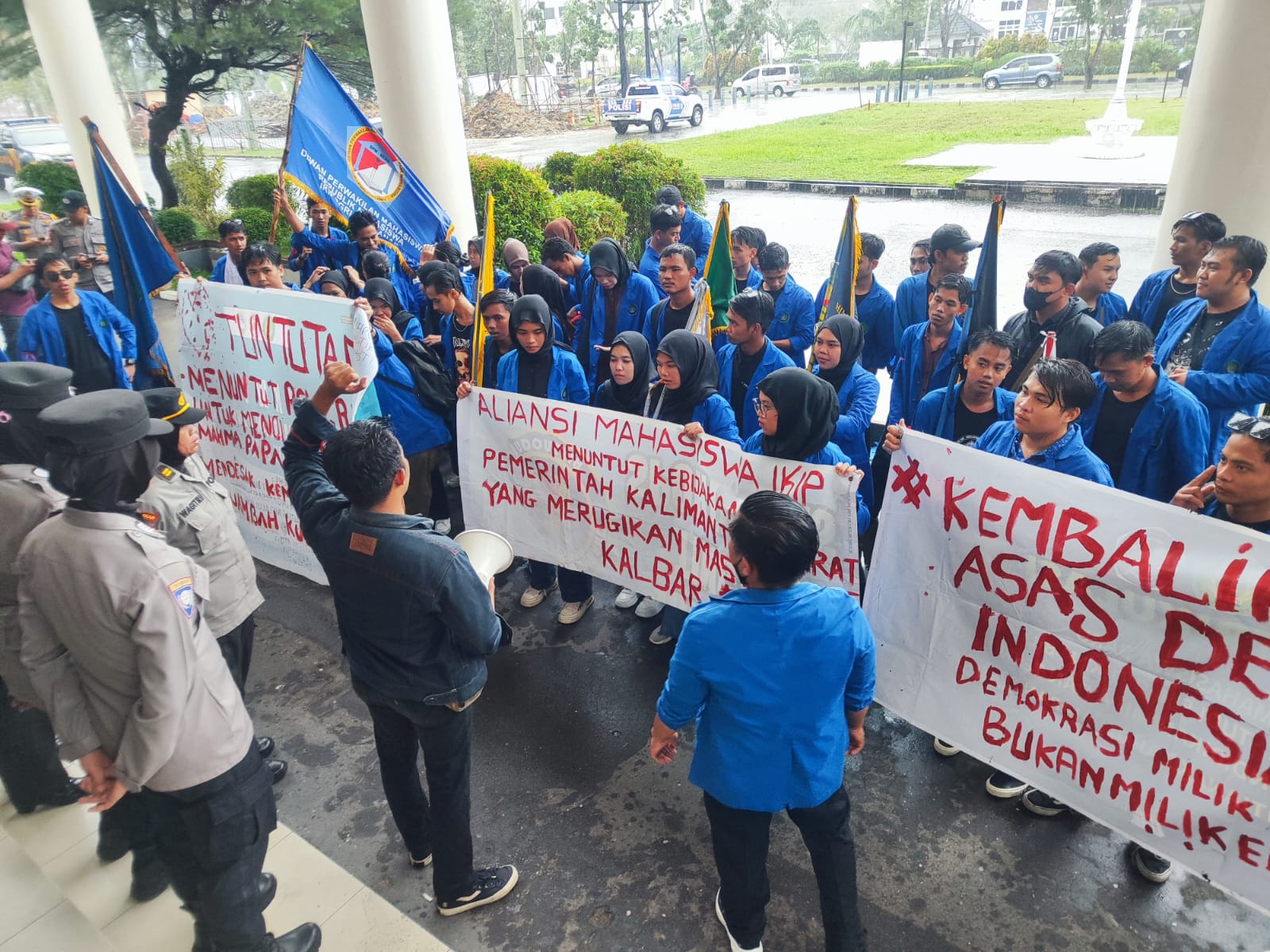 Foto: Puluhan mahasiswa IKIP PGRI Pontianak mengeruduk gedung DPRD Kalbar dan menyampaikan aspirasinya kepada wakil rakyat meskipun almamater biru diguyur hujan deras.