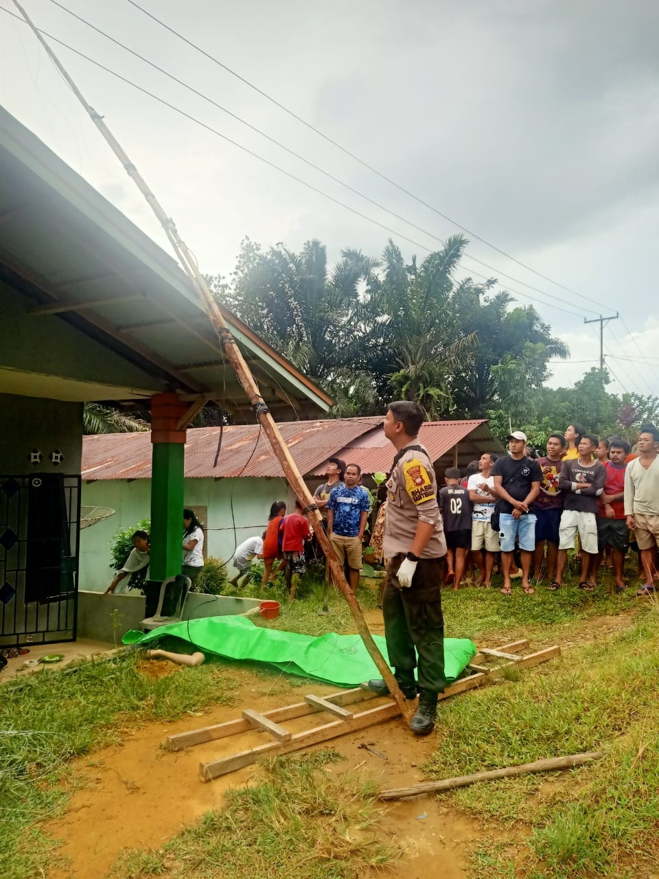 EVAKUASI: Polisi bersama warga mengevakuasi korban tersengat arus listrik di Desa Sidas Kecamatan Sengah Temila, Selasa (24/10).