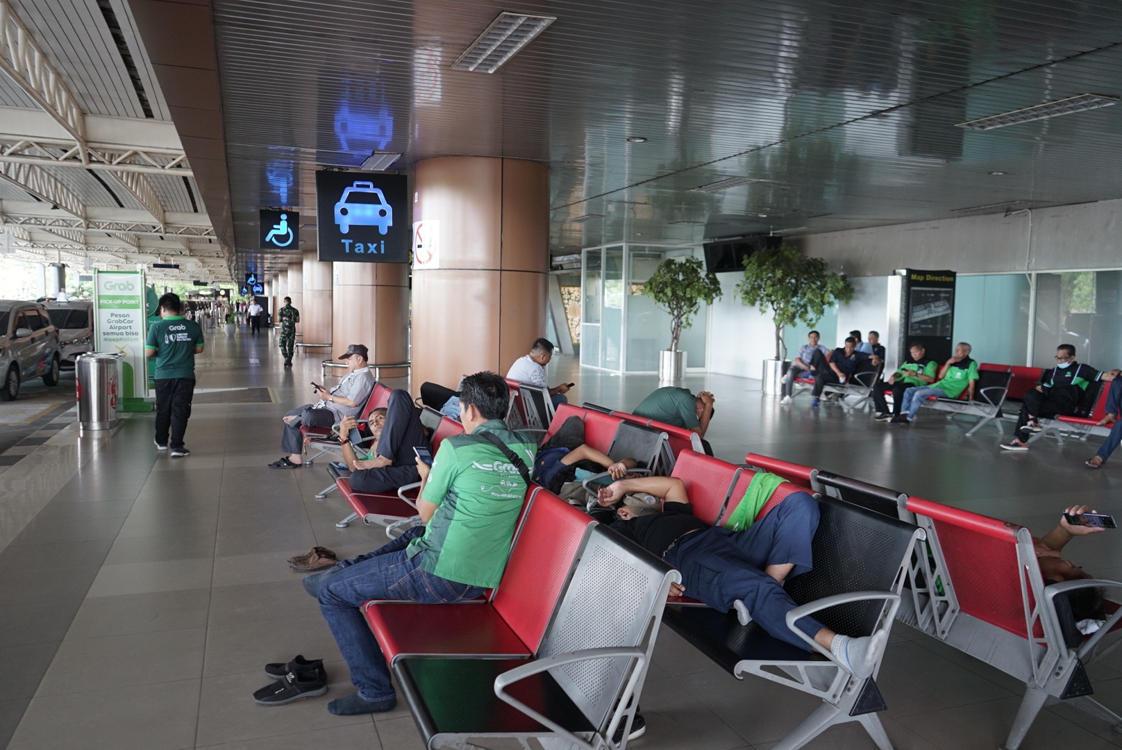 SEMPAT DELAY: Sejumlah sopir angkutan di Bandara Internasional Supadio tidur-tiduran di kursi tunggu kedatangan akibat tidak adanya penumpang yang turun di bandara.