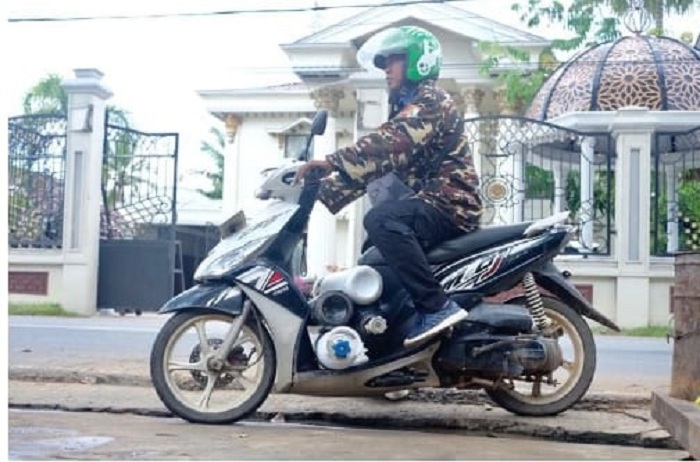 ANTAR TABUNG OKSIGEN: Ubai dengan sepeda motor tunggangannya mengantarkan tabung-tabung oksigen selama masa pandemi lalu. Semua jasa pelayanan yang dilakukannya tersebut tanpa pernah menerima pamrih.