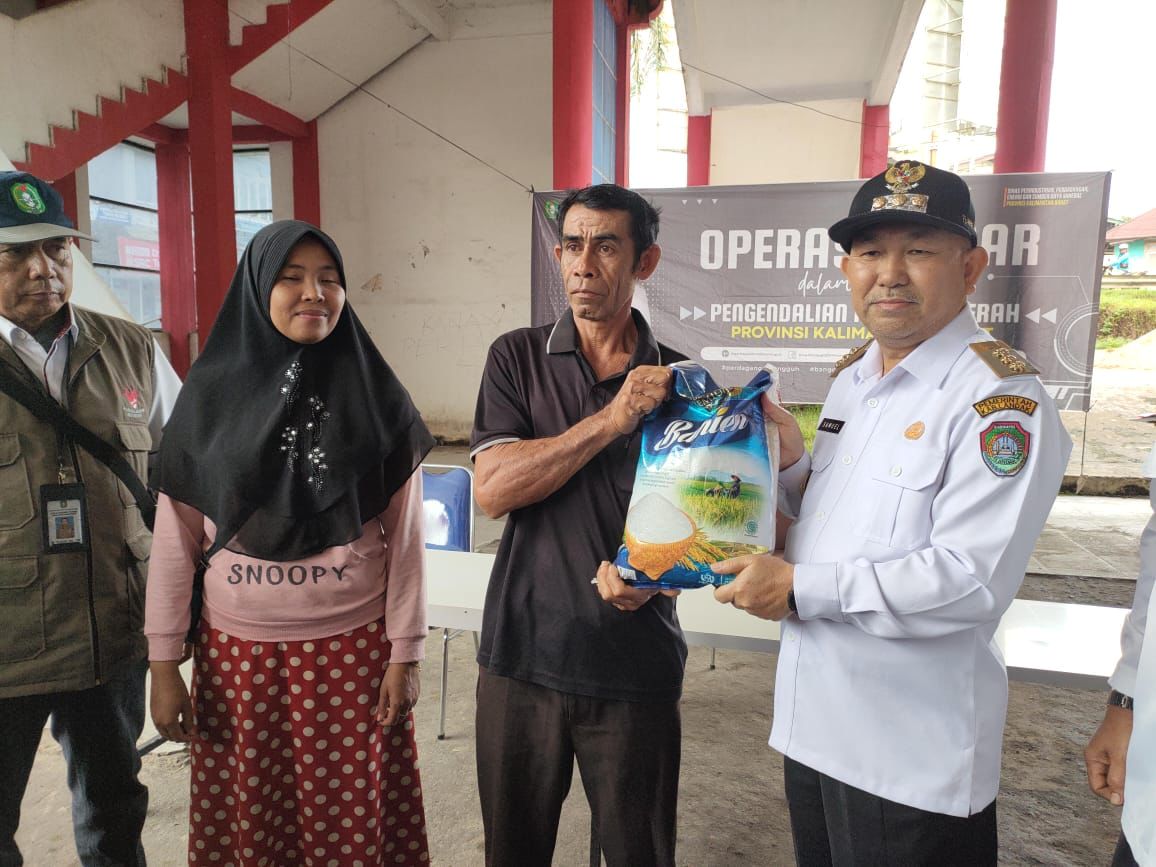 SEMBAKO: Pj Bupati Landak Samuel menyerahkan sembako murah kepada warga secara simbolis di Terminal Dara Itam Ngabang, Rabu (15/11).