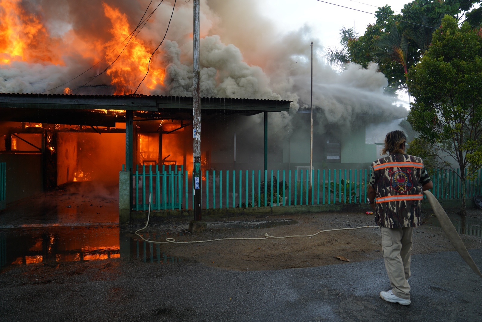 Petugas pemadam kebakaran saat melakukan upaya pemadaman api yang membakar dua rumah dinas perwira TNI Angkatan Darat di Jalan Palapa, Kota Pontianak, Kamis (23/11), siang.
