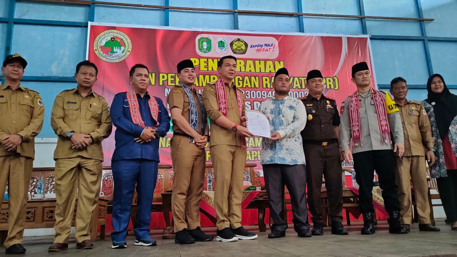 PENYERAHAN IPR: Bupati Kapuas Hulu Fransiskus Diaan didampingi Wakil Bupati Kapuas Hulu Wahyudi Hidayat menyerahkan dokumen IPR kepada penambang emas di Desa Nanga Suruk, Kecamatan Bunut Hulu.