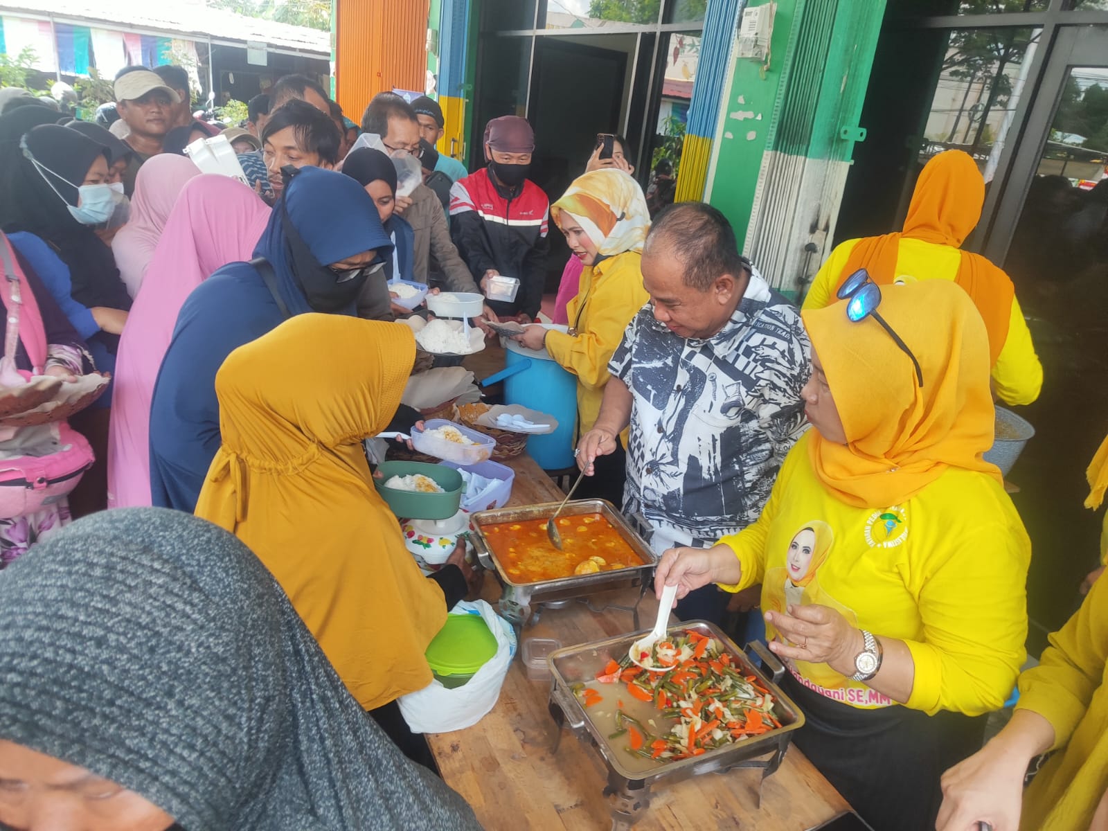 Heri Mustamin, anggota DPRD Kalbar Dapil Kota Pontianak nomor urut 1 bersama dengan Hj. Wina Handayani, Pengurus Yayasan Peduli Masyarakat Khatulistiwa membagikan lauk pauk makanan gratis.