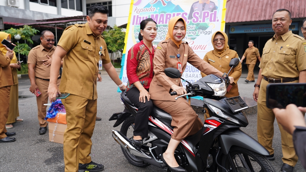 Kepala Disdikbud Kalbar Rita Hastarita membonceng Meries untuk mengetes sepeda motor yang dihadiahkan kepada guru honorer SMKN 1 Ketungau Hulu tersebut, Selasa (28/11).