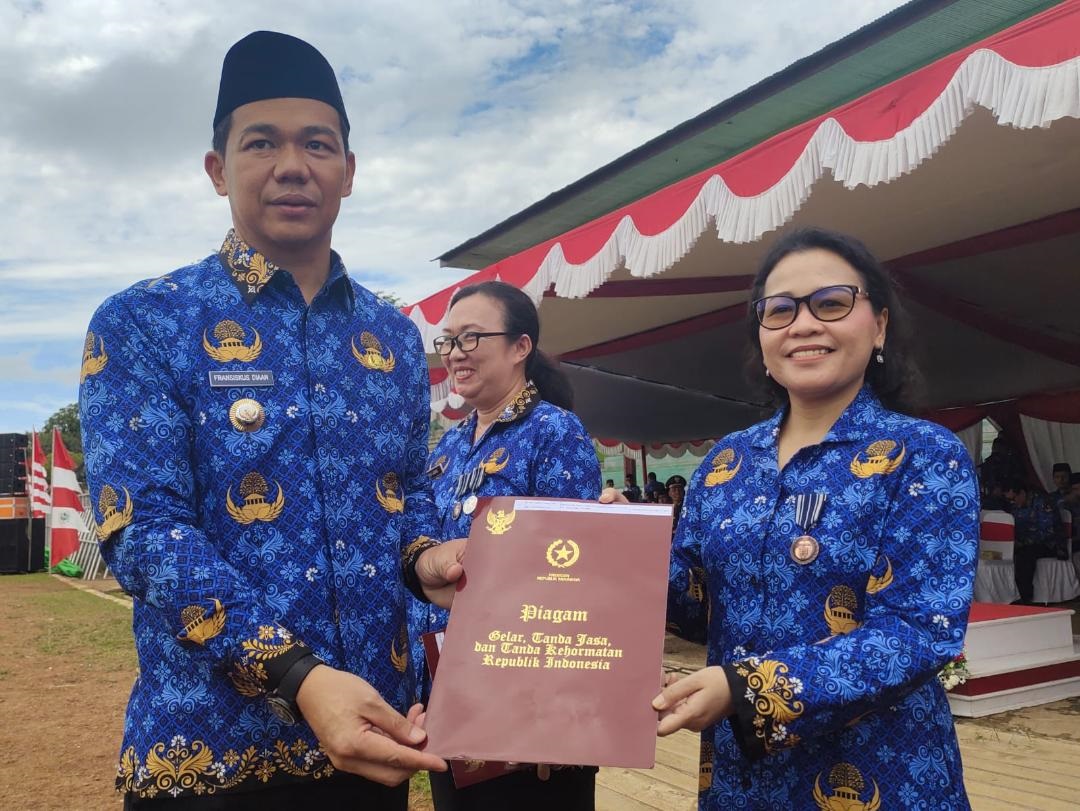 PENYERAHAN PENGHARGAAN: Bupati Kapuas Hulu Fransiskus Diaan saat menyerahkan penghargaan Satya Lencana Karya Satya kepada ASN Kapuas Hulu yang mengabdi puluhan tahun dalam Upacara Hari Korpri.