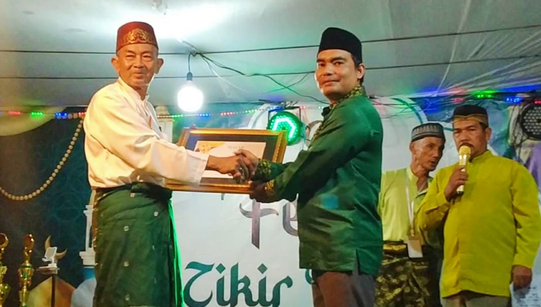 Panitia Festival Zikir di Kecamatan Semparuk berikan penghargaan kepada Ketua Majelis Zikir Assambasy Galih Usmawan atas peran sertanya sukseskan kegiatan.