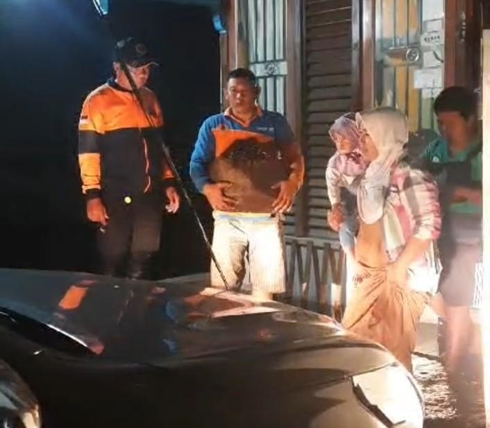 EVAKUASI: Tim BPBD Kabupaten Kapuas Hulu saat mengevakuasi warga yang terdampak banjir di daerah Dogom, Kota Putussibau, Selasa (5/12) malam.
