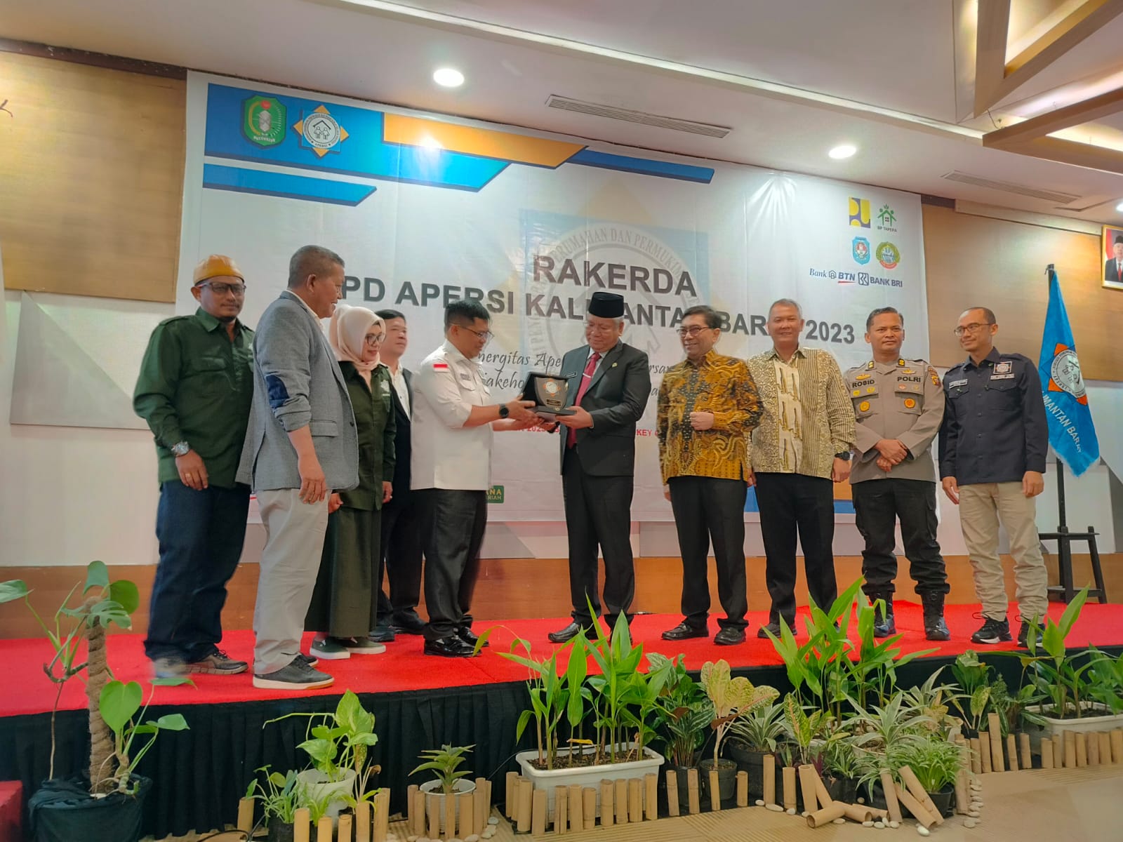 Ketua Umum Apersi Pusat, Junaidi Abdillah memberikan cinderamata kepada Pj Gubernur Kalbar Harisson saat pembukaan Rakerda Apersi Kalbar 2023, Jumat (8/12).