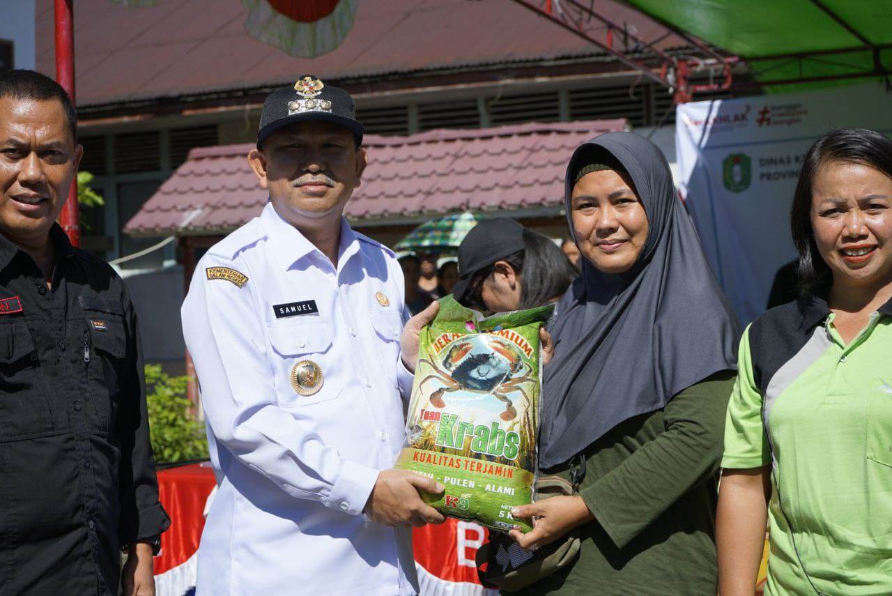 PANGAN: Pj Bupati Landak Samuel menyerahkan pangan murah kepada warga di Desa Serimbu Kecamatan Air Besar Rabu (6/12).