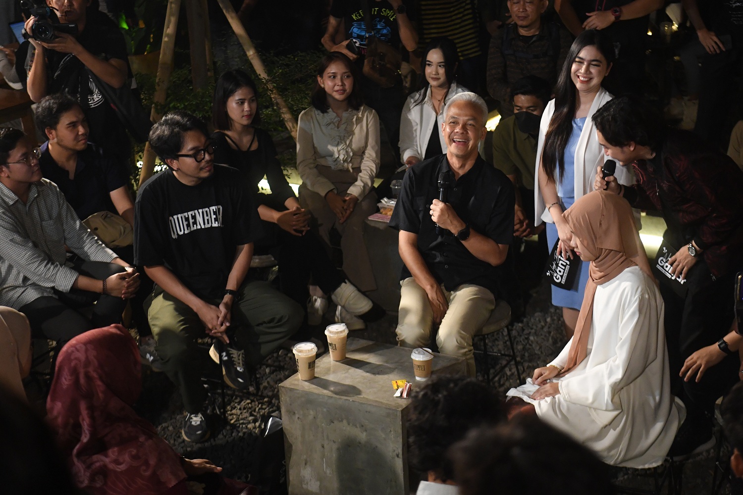Calon Presiden nomor urut 3 Ganjar Pranowo (keempat kanan) tertawa saat berdialog dengan generasi milenial dan GenZ di Bekasi, Jawa Barat, Jumat (15/12/2023). Dalam dialog tersebut Ganjar mendengar keluhan kaum muda seperti sulitnya mencari lapangan peker