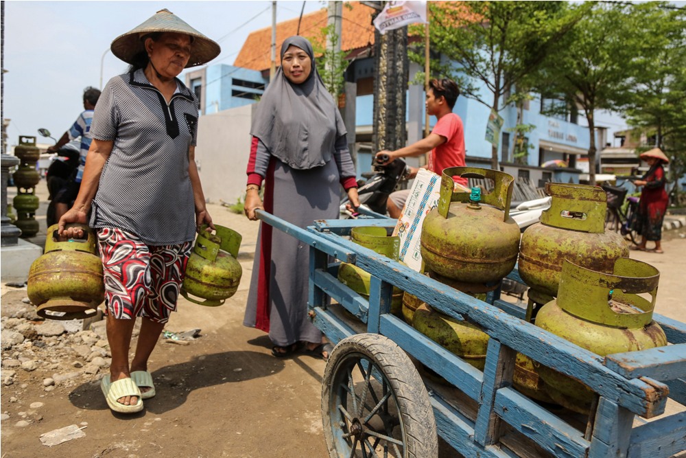 Dua orang perempuan membawa tabung gas elpiji 3 kilogram, beberapa waktu lalu. Mulai 1 Januari 2024, warga yang hendak membeli gas melon harus menunjukkan KTP atau KK.