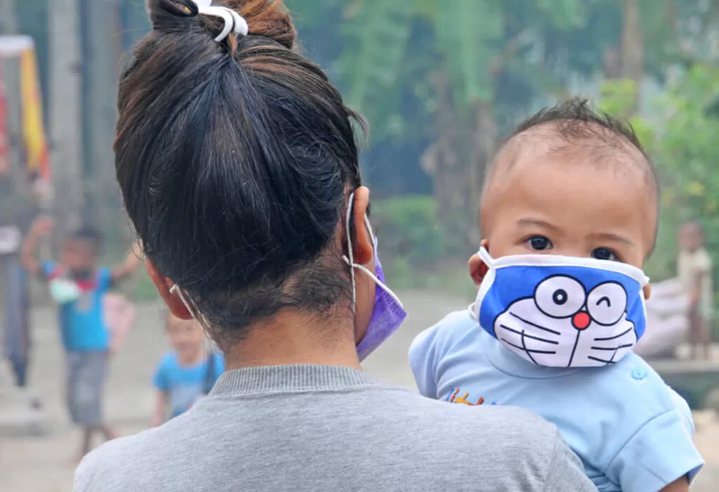 ASAP: Seorang balita harus menggunakan masker saat digendong ibunya beraktivitas di luar rumah Jalan Raya Kakap, Kubu Raya. Ancaman ISPA menghantui balita dan anak-anak saat musim kabut asap.