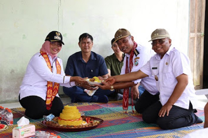 POTONGAN TUMPENG: Budi Utoyo menerima potongan nasi tumpeng dari Bupati Mempawah Erlina.