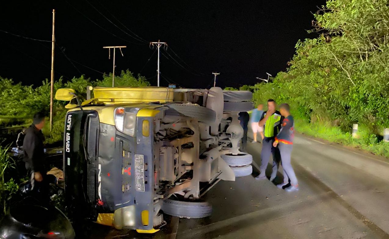 TERGULING: Truk yang mengangkut air mineral terguling di pinggir jalan di kawasan Pelabuhan Kijing.