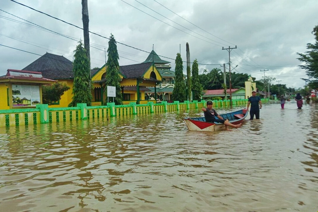 TERENDAM: Warga beraktivitas menggunakan sampan akibat banjir yang merendam di depan Keraton Ismahayana Kecamatan Ngabang, Landak, Kalimantan Barat, Minggu (7/1).