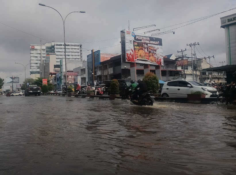 GENANGAN: Pengendara melintas di Jalan Gajah Mada Pontianak yang tergenang akibat tingginya air pasang laut ditambah hujan yang mengguyur, membuat sejumlah permukaan rendah di Kota Pontianak terendam.