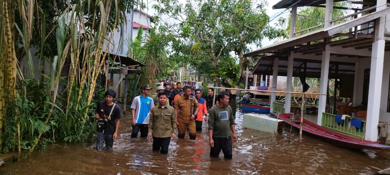 TINJAU BANJIR: Bupati Sambas Satono turun ke air saat bertemu warga yang terdampak banjir di wilayah Kecamatan Sejangkung, Selasa (16/1).