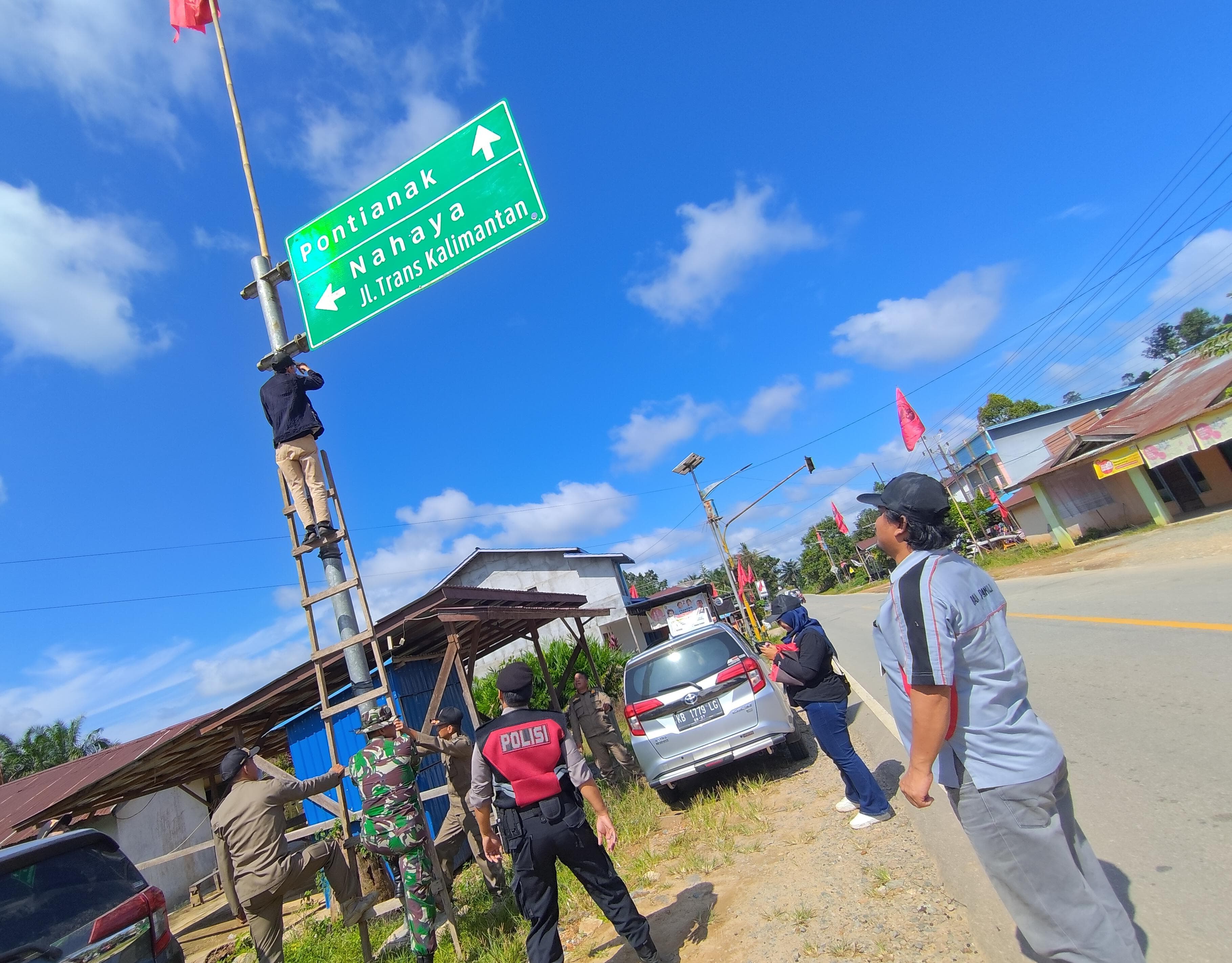 Petugas menurunkan APK yang terpasang di fasilitas umum di Kecamatan Ngabang, Sabtu (27/1).