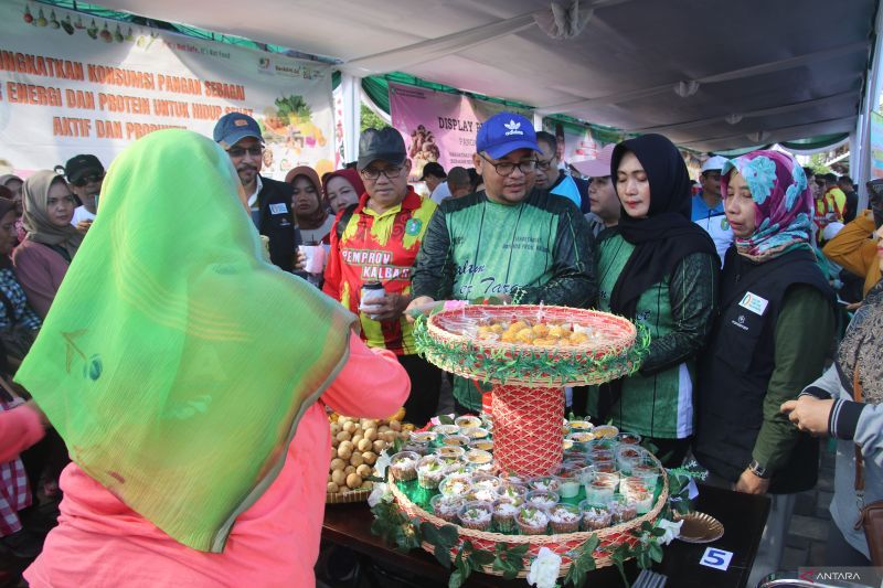KULINER: Pj Sekda Kalbar M Bari di dampingi istri dan jajaran OPD Kalbar menikmati kuliner jajanan pasar pada Gelar Pangan Murah yang dilaksanakan di halaman Kantor Gubernur Kalbar, Sabtu (27/1).