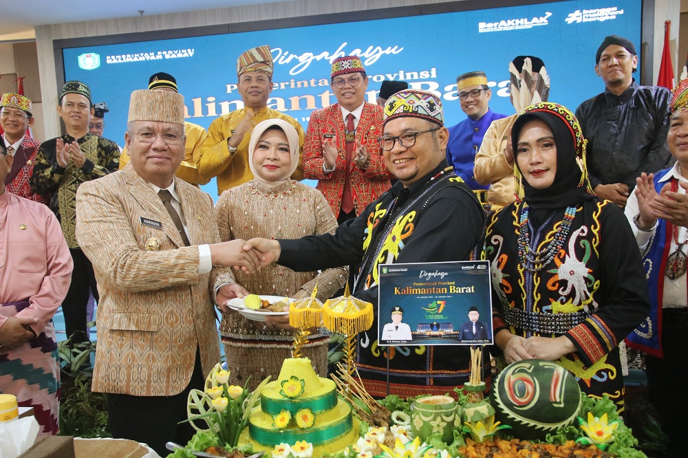 TUMPENG : Pj Gubernur Harisson memberikan potongan tumpeng kepada Pj Sekda Kalbar Mohammad Bari.