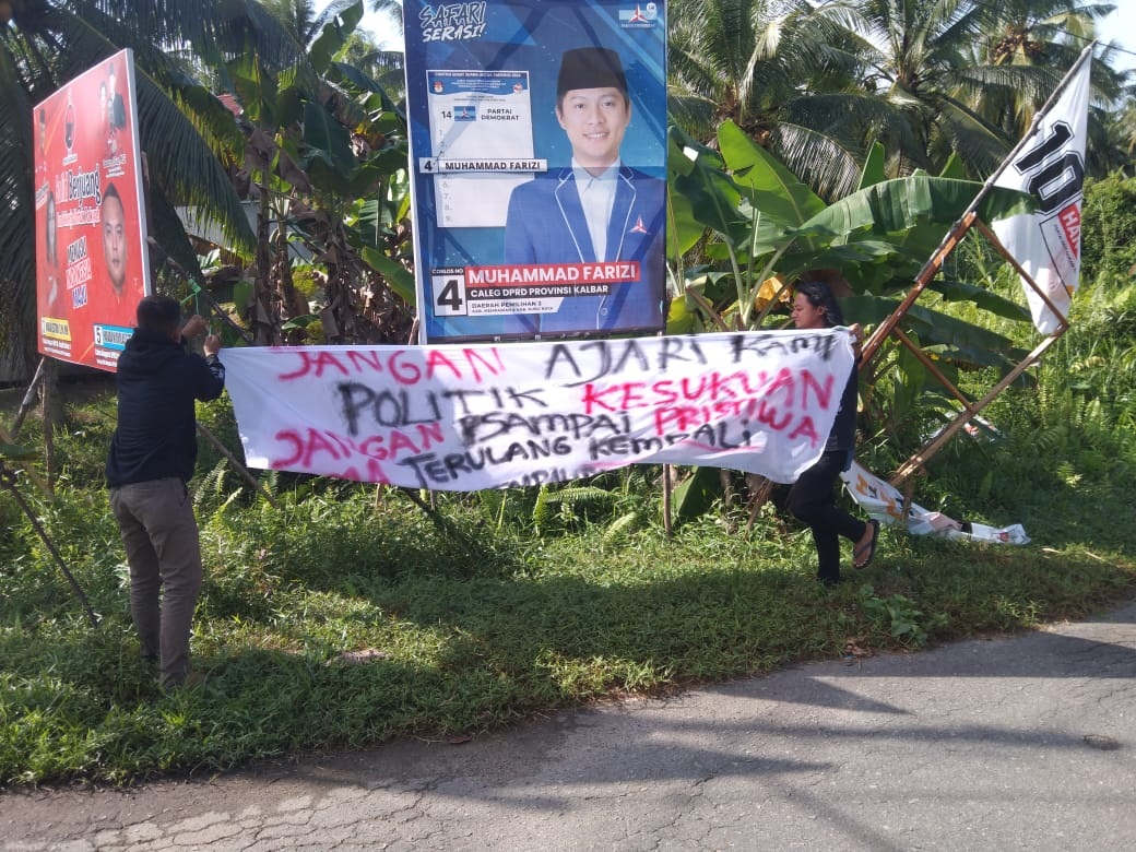 COPOT: Petugas bawaslu saat mencopot spanduk rasis di jalan dr Rubini Mempawah.