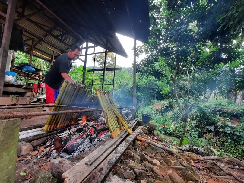 MEMASANG LEMANG: Tengku Syahriannur tampak sedang sibuk memasak lemang.