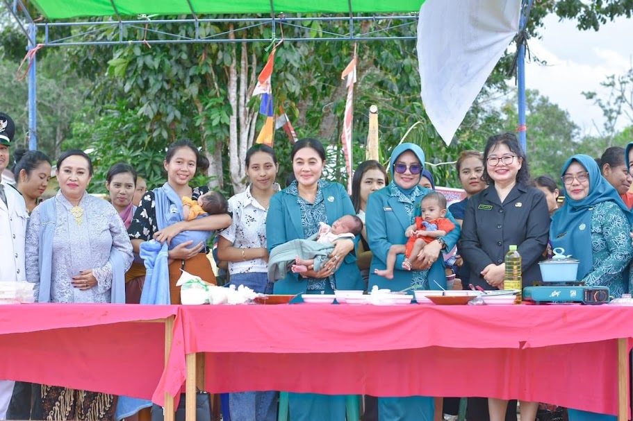 MENGENDONG BAYI: Ketua TP PKK Kabupaten Ketapang, Elisabeth Betty Martin, menggendong bayi saat memberikan makanan tambahan kepada bayi yang terindikasi stunting di halaman Kantor Camat Jelai Hulu.