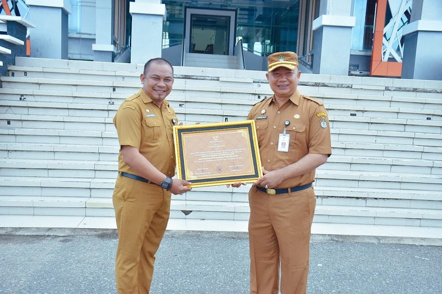 PENGHARGAAN: Sekda Ketapang, Alexander Wilyo, menyerahkan Indek Reformasi Birokrasi 2023 yang diterima Asisten Sekda Bidang Administrasi Umum sebagai Ketua STU Reformasi Birokrasi, Devy Harinda.