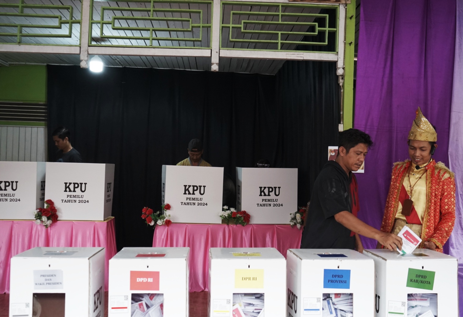 Petugas Tempat Pemungutan Suara (TPS) di Gang H. Arsyad TPS 045 Kelurahan Saigon menggunakan baju adat multi etnis. Hal ini sebagai bentuk simbolis keanekaragaman suku dan budaya, meski beda pilihan.