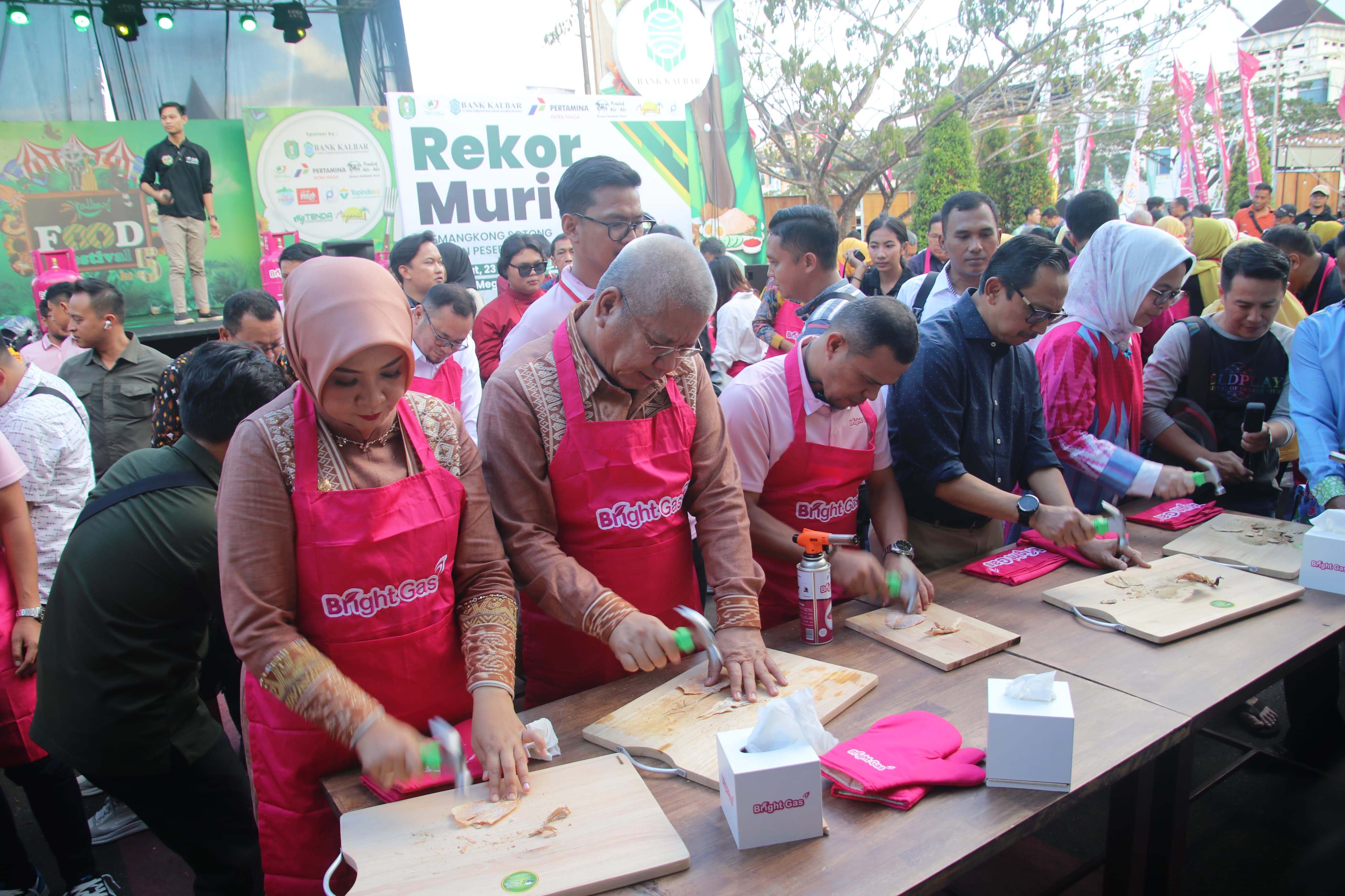 REKOR MURI: Pj Gubernur Kalbar Harisson dan Pj Ketua TP PKK Kalbar, Windy Prihastari saat ikut memecahkan rekor Muri memukul sotong kering dalam gelaran Kalbar Food Festival 2024, Jumat (24/2).