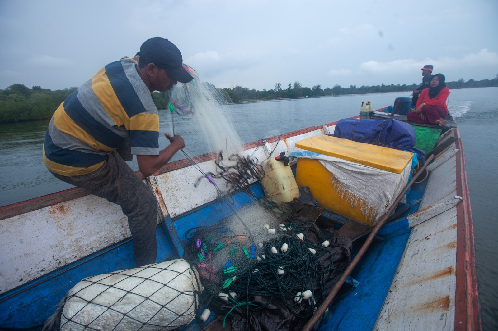 MENCARI IKAN : Neka (baju merah) bersama suaminya, Salmin (paling depan) mencari ikan di sekitar Pulau Gelam. Pulau kecil di Kendawangan tersebut kita terancam tambang pasir kuarsa. /Victor Fidelis