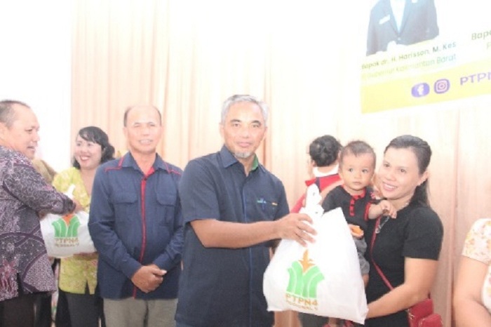 SERAHKAN : Region Head PTPN IV Regional V Khayamuddin Panjaitan menyerahkan bantuan kepada warga Desa Amboyo Inti dalam rangka pengentasan stunting.