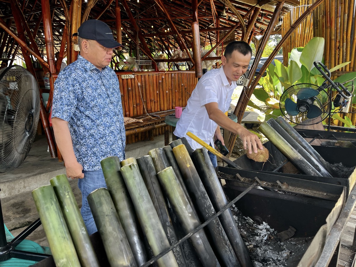 Harisson melihat Adi sang owner memproses masak ayam dalam bambu di Sosok.