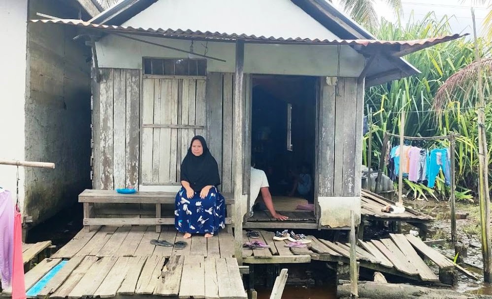PERLU BANTUAN: Insirani, warga Desa Sui Purun Kecil, Kecamatan Sungai Pinyuh, di depan rumahnya yang tak layak huni.