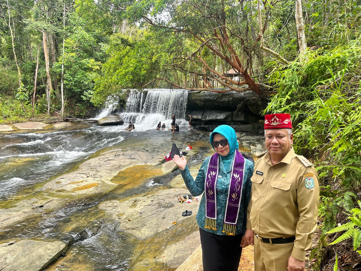 Harisson beserta Windy berpose di depan Riam Pancur Aji. Riam ini merupakan salah satu dari banyak riam di kawasan ini.
