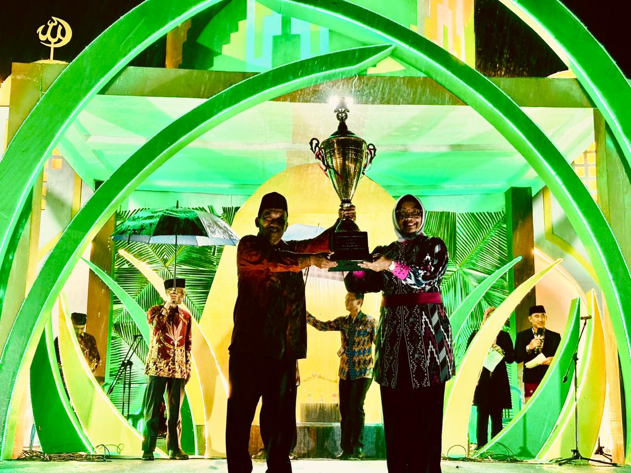 PIALA : Bupati Erlina menyerahkan piala bergilir MTQ kepada Camat Sui Pinyuh.
