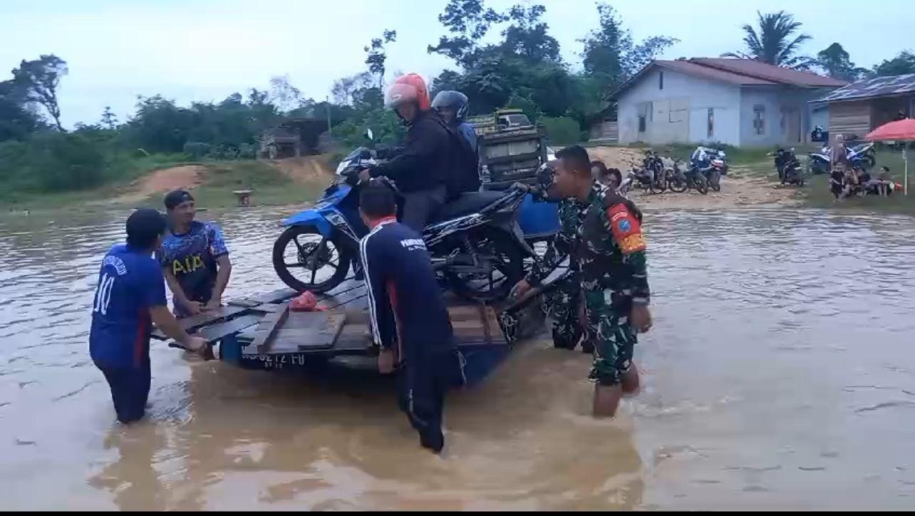 BANTU WARGA: Curah hujan yang tinggi membuat ruas jalan Desa Nanga Nuar, Kecamatan Silat Hilir, membantu warga yang kesusahan karena banjir.