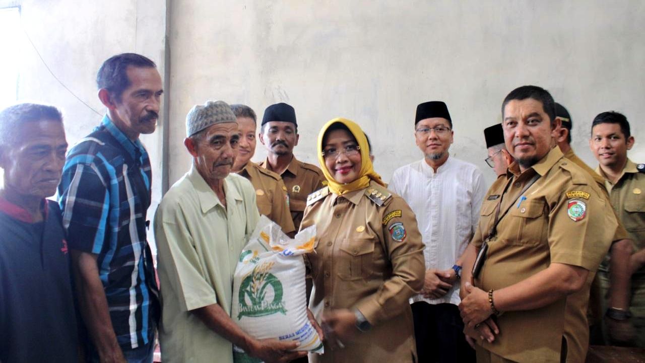 BANSOS : Bupati Erlina saat menyerahkan Bansos beras kepada masyarakat Desa Sengkubang.