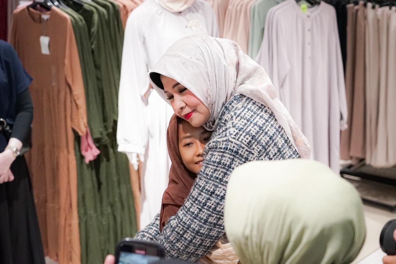 Pj Ketua TP-PKK Kalbar Windy Prihastari memeluk salah satu anak yang merasa haru ketika diajak belanja baju lebaran, Sabtu (23/3).