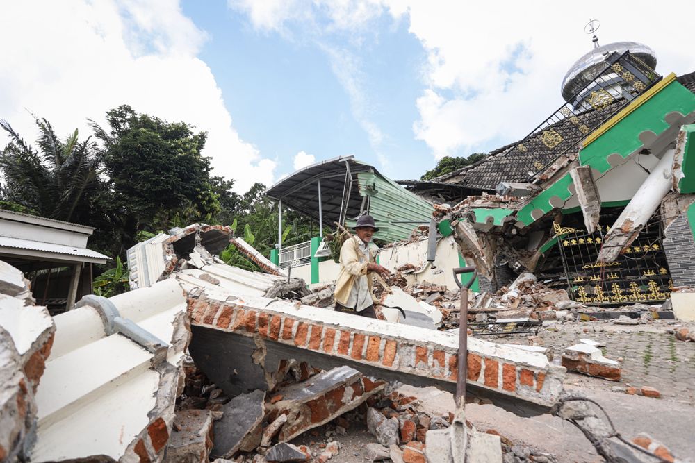 Warga membersihkan puing-puing bangunan rumah yang rusak akibat gempa di Desa Suwari, Sangkapura, Pulau Bawean, Gresik, Jawa Timur, Minggu (24/3/2024).