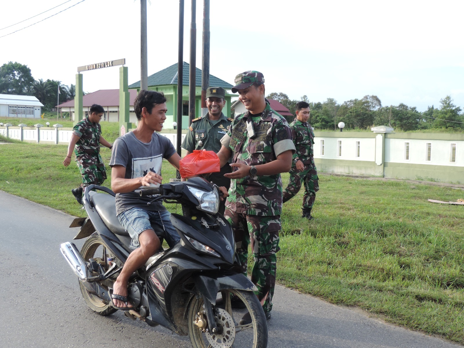 BERBAGI: Pengendara sepeda motor yang melintas mendapat takjil gratis dari Dandim Landak, Selasa (26/3).