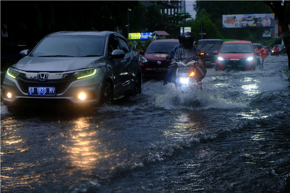 : Sejumlah pengendara motor dan mobil melintasi banjir di Jalan KH Ahmad Dahlan, Pontianak, Kalimantan Barat, Jumat (8/3/2024).