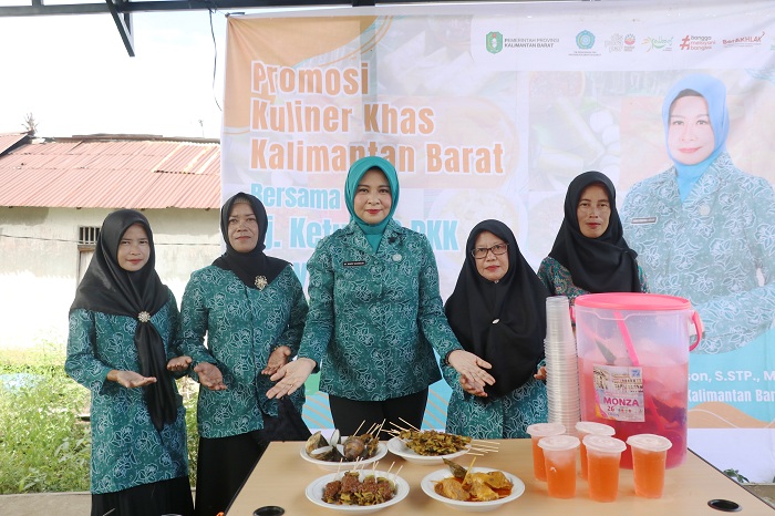PROMOSI: Pj Ketua TP-PKK Kalbar, Windy Prihastari menunjukkan olahan makanan dari cumi dan kepah yang telah dimasak bersama warga Desa Sepuk Laut, Kamis (28/3).&nbsp;