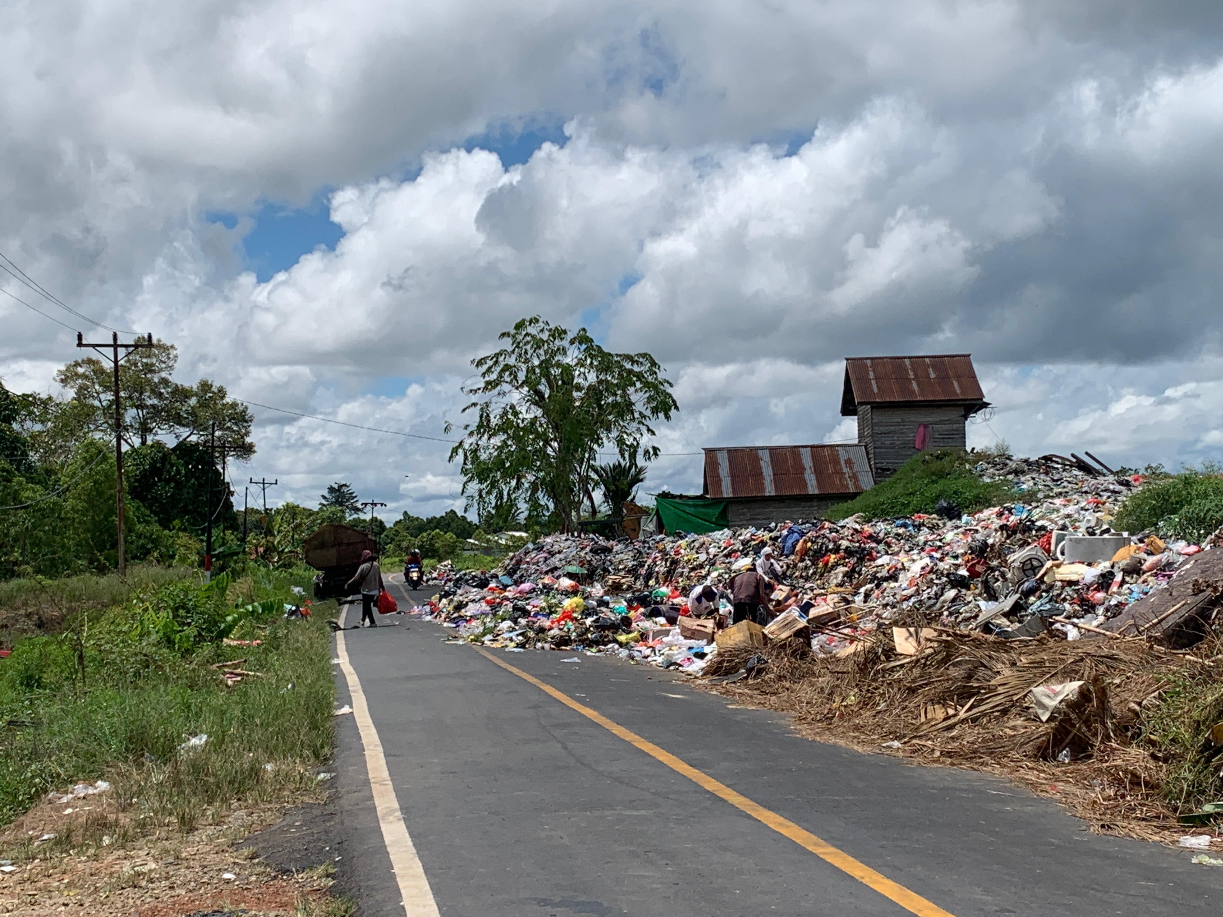 Tampak warga sedang melintas di TPA sampah di Putusibau, banyaknya yang sampah yang menumpuk hingga membuat sampah meluber ke bahu jalan.