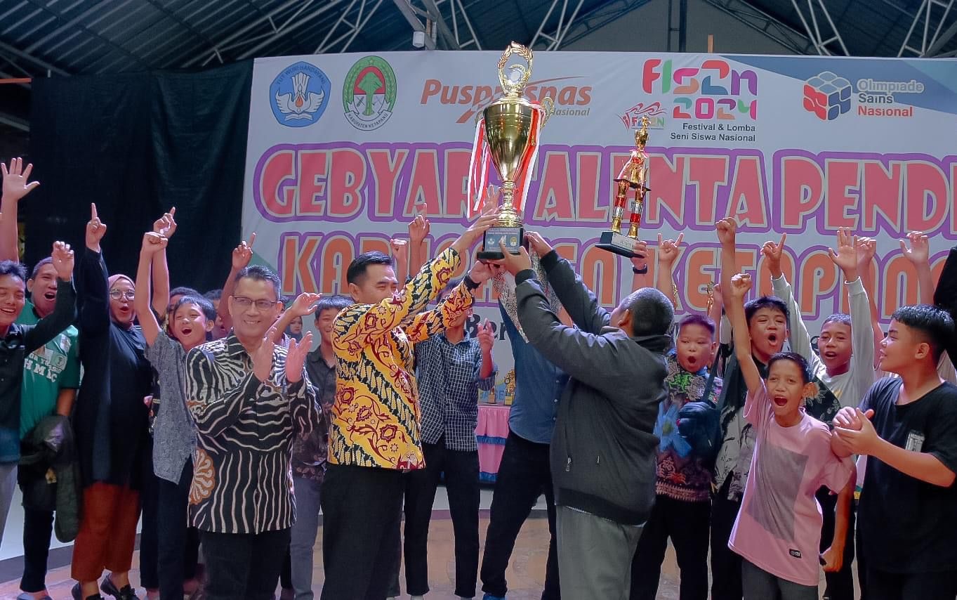JUARA UMUM: Asisten Sekda, Heryandi, menyerahkan piala kepada juara umum pada Gebyar Talenta Pendidikan 2024, Kamis (2/5).