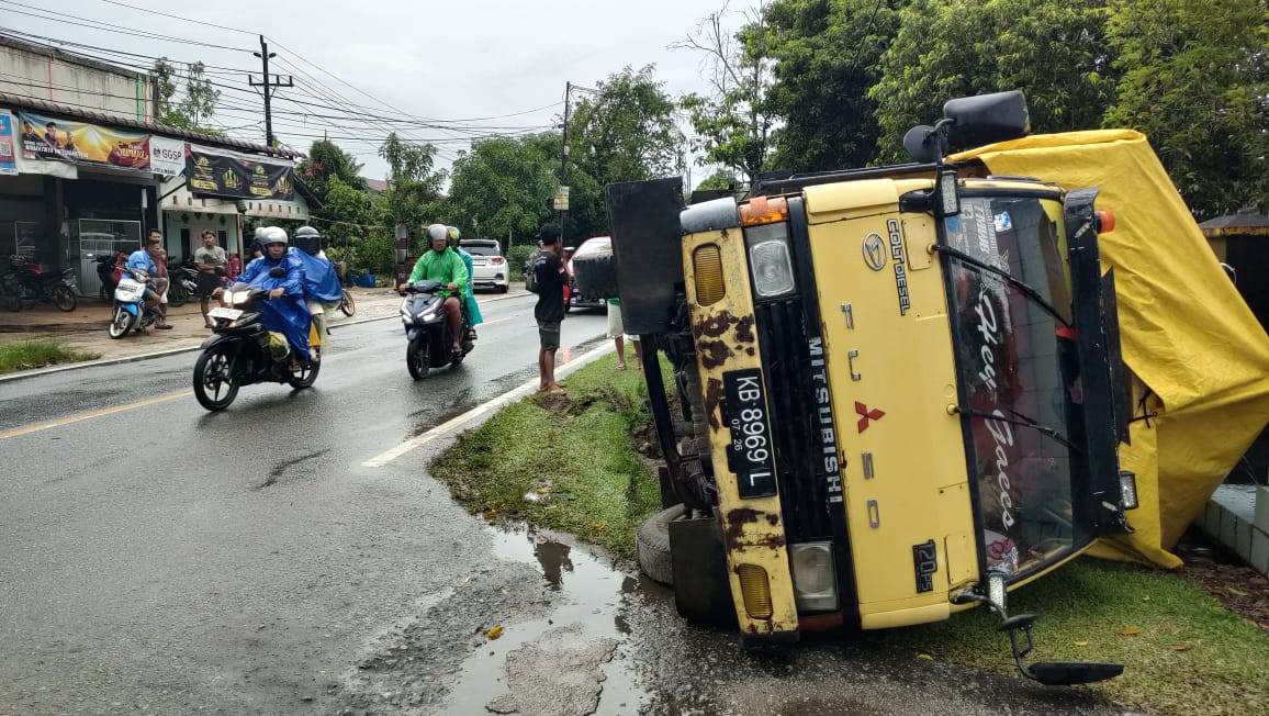 Hindari Tabrakan: truk bermuatan semen yang terguling di Jalan Anjongan.