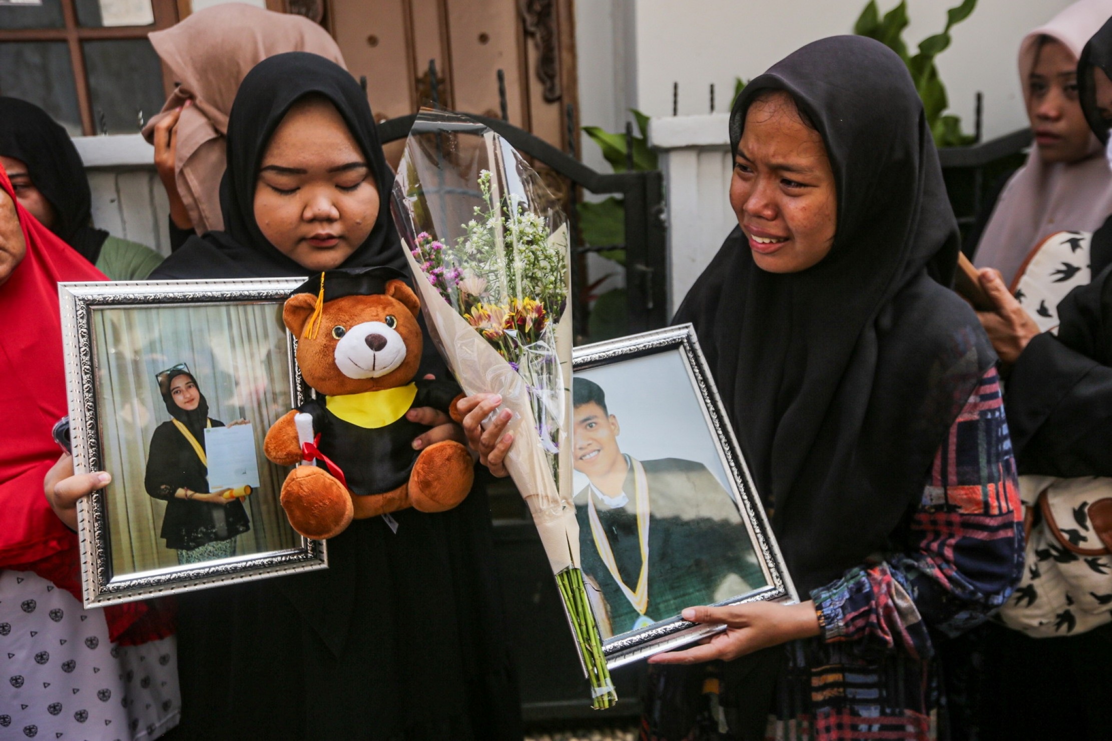 Keluarga dan kerabat menangis sambil memegang foto semasa hidup korban kecelakaan bus karyawisata SMK Lingga Kencana di rumah duka, Parung Bingung, Kota Depok, Jawa Baray, Minggu (12/5/2024).